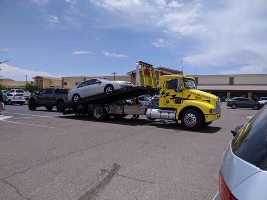 Car being loaded onto the tow truck.