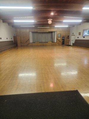 Large room with wooden floor and stage