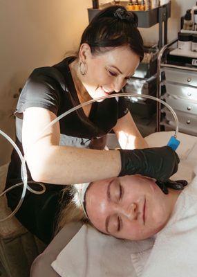 Andrea performing a microdermabrasion treatment for her client.