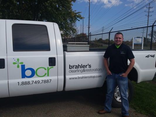 Project Manager, Cody Walker by one of our company vehicles