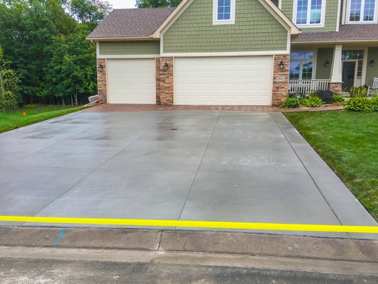 Broom finished concrete driveway with stained and textured garage front.