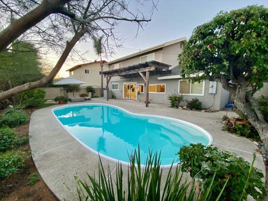 Stunning backyard with a pool, pergola, and lush landscaping for relaxation.