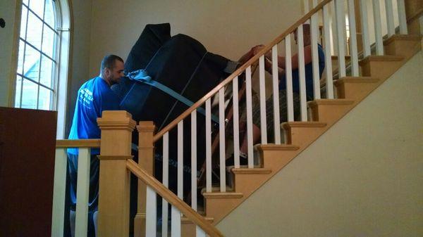 At landing of stairwell, putting the piano on end to turn the corner.