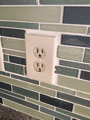 Contractor claims that this is the correct way to tile around an outlet and wants to be paid in full.