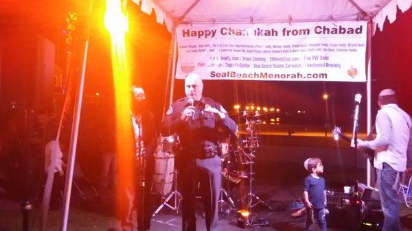 Seal Beach Police Officer wishing the large celebratory crowd at the Pier a Happy Chanukah.on December 10, 2017