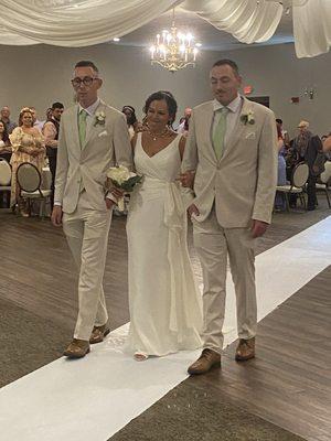 The beautiful Bride walked down the aisle by her two handsome sons Ryan and Brandan