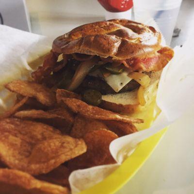 The Tazer - 1/2# burger w/ Swiss, grilled onions and jalapeños on pretzel bun. Added bacon.  Delicious house made potato chips.