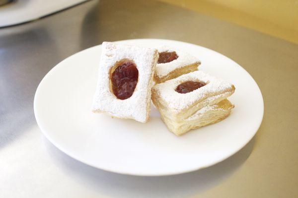 Puff dough pastry with strawberry jam filling and powder sugar on top. (Contains: Wheat)