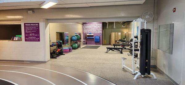 Stretching room with various workout equipment, a massage chair, and upstairs restroom.