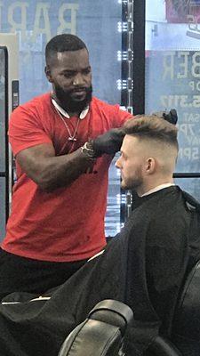 This is Eric the barber  looks like a personal trainer but is a really great detail barber loves to cut hair .. high skin fade