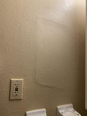 poorly done patch job in the bathroom, assuming from an old hole in the wall