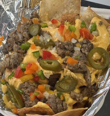 Our fresh fried tortilla chips topped with our signature con queso, moist mouth watering smoked brisket, peppers, onions and jalapeños!