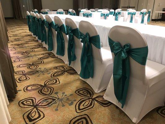 Head table with jade satin sashes and white spandex chair covers