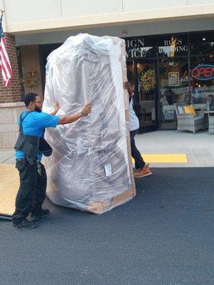 Loading a part of a sectional couch from Up 2 Us furniture store.