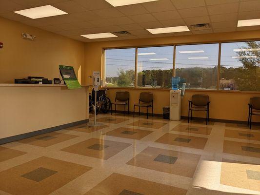 Lobby. Receptionist on left behind screen kiosk to check in.