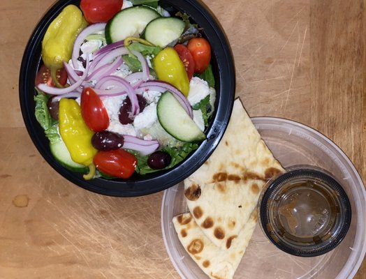 Half a Mediterranean salad served with roasted garlic vinaigrette and pita bread.