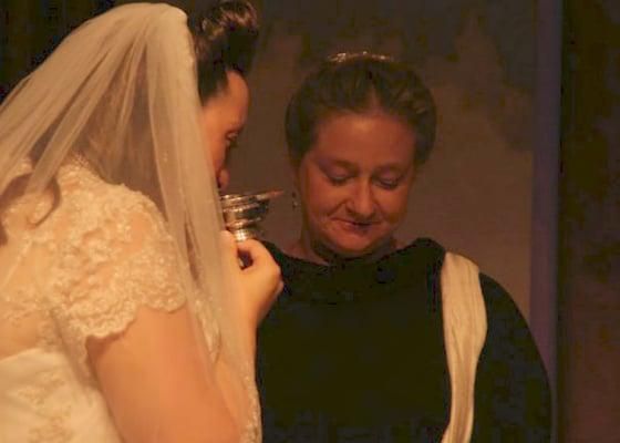 A traditional bride takes a sip from the blessing cup