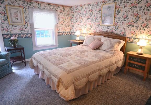 The Sage Room is a sunny carpeted room with a closet, comfy rocking arm chair, and a bathroom with a two-person walk-in shower.