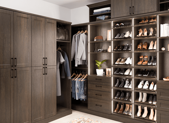 Custom Master closet with slanted shoe shelves, led lighting, vertical shelving, and cabinet doors.