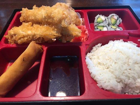 Tempura chicken Bento box with tempura veggies, California roll, spring roll and white rice.