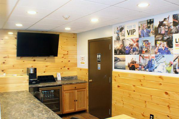 Waiting room with gender neutral bathroom, coffee station, tv, and free water