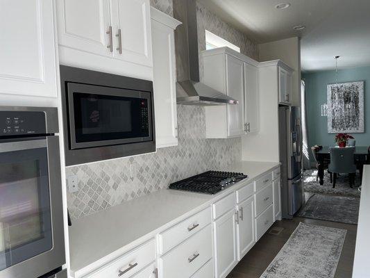 Newly painted kitchen cabinets, by  Augusto. Benjamin Moore in Advance finish, Chantilly Lace color, semi-gloss. Love it!