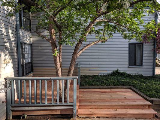 Pressure treated deck with existing railing reused and rotted siding replaced.