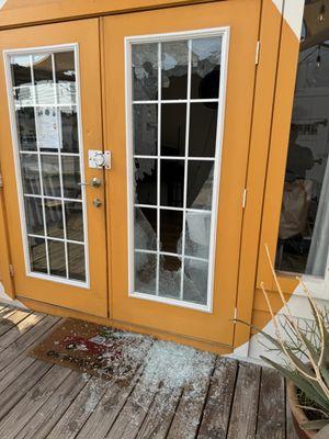 A person threw 2 rocks and broke the door window.