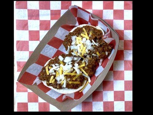 A family style sloppy Joe recipe on hotdogs or hamburgers with various sides and condiments.