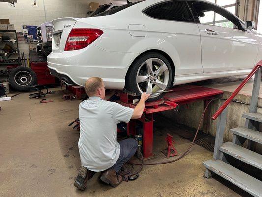 Aligning rear wheel--Travis ensuring wheel stays aligned when bolts receive final torque.