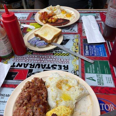 Corn beef hash , scrambled eggs. Second plate, fried bologne with toast, potatoes and sunny side eggs.