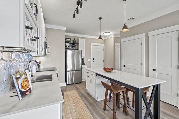 260-unit Upper East Apartments remodel. Hatteras White cabinets & Primordia quartz; Island: Hatteras Slate cabinets & Arctic White quartz.