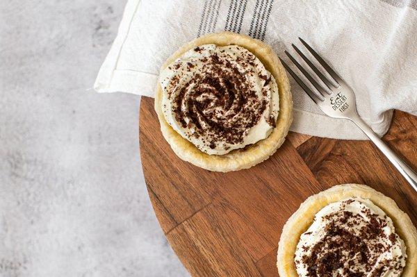 Chocolate cream pies topped with fresh whipped cream and grated Hershey's chocolate.