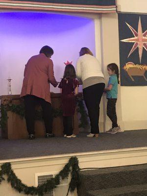 Children and mother lighting Advent candle.