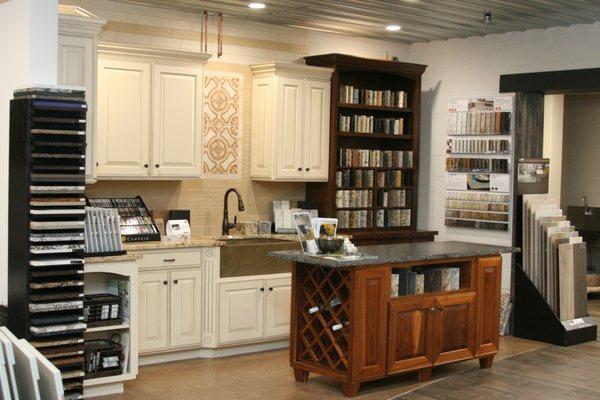 Superior Floorcoverings & Kitchens showroom. Interior view of kitchen cabinet display feauting countertop options, accent wall and island.