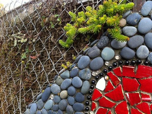 A custom designed living wall built using burlap, stone and tile.