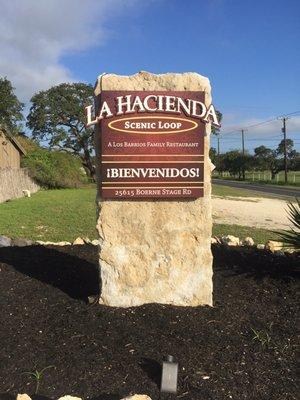 metal sign face with dimensional lettering anchored to limestone rock.