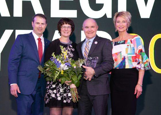 Home Instead Founders Paul & Lori Hogan present the 2018 North American CAREGiver of the Year Award to our very own Barb H!