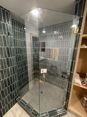 A Custom Frameless Shower Door and Panel with Showerguard Glass and Brushed Bronze Hardware