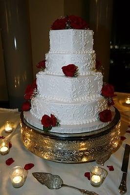 wedding cake with alternating round and hexagonal tiers and scroll designs