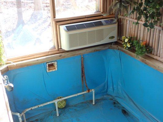 Homemade indoor swimming pool with an air conditioner.