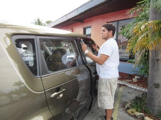 Pablo installing Vent visors on a Kia Soul for Kia of Vero Beach