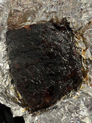 Sauce on the ribs after I asked for it on the side. Ribs so burnt and tough that I couldn't chew through it.