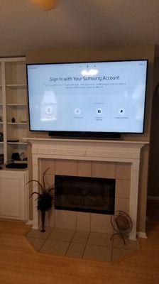 TV mounted above fireplace with wire concealment and sound bar bracket