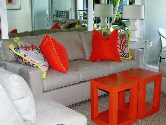 Tan sectional sofa with orange accent pillows and orange lacquer tables to make a statement!