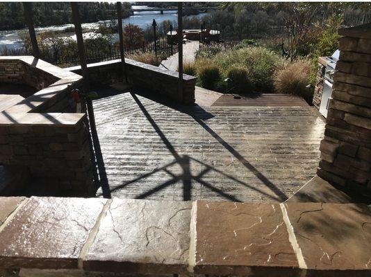 Stamped and sealed wood plank concrete patio. Block and stone veneer wall.