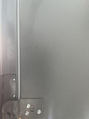 The first picture is missing a cover for the right side door hinge. The second picture was provided a cover for the left side door hinge.