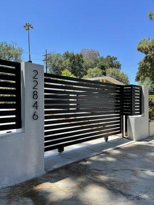 Modern style horizontal fence and driveway gate powered by LiftMaster and Yale keypad on pedestrian door.