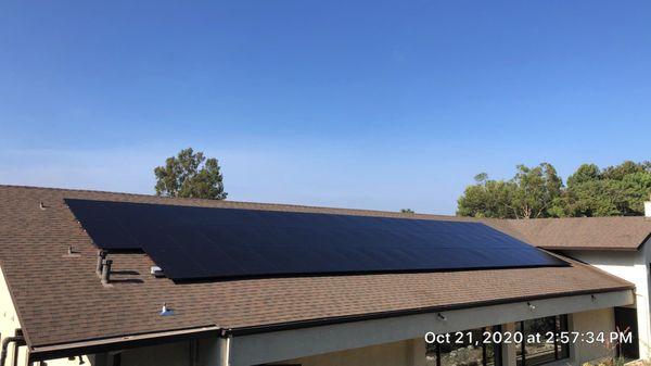 Matte black solar panel installation on a brand new shingle roof.