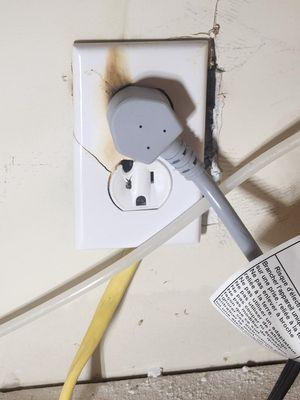 Charred outlet with wire sticking out from underneath